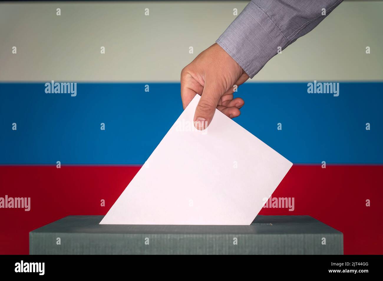russia simbolo delle elezioni. La mano maschile depone un foglio di carta bianco con un segno come simbolo di una carta di voto sullo sfondo del rus Foto Stock