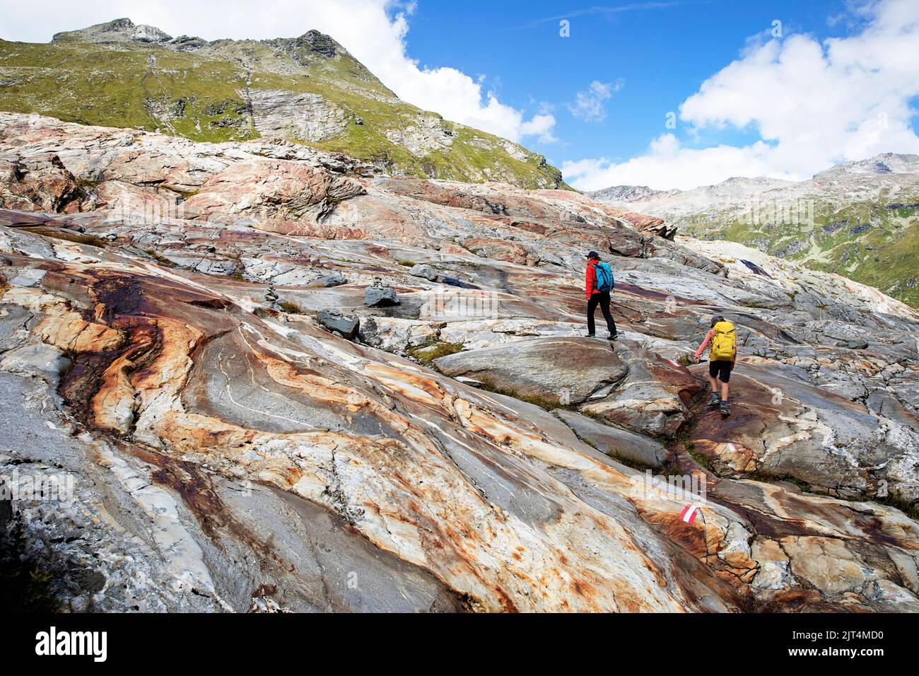 Madre e figlio camminano su rocce colorate su una morena del ghiacciaio su un bellissimo sentiero del ghiacciaio Innergschlöss fino al ghiacciaio di Schlatenkees, Tirolo orientale, Austria Foto Stock