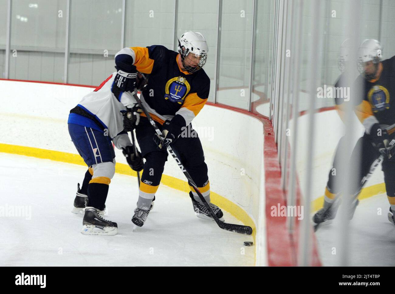 Stan Johnson, studente dello U.S. Naval War College (NWC) di Newport, R.I., batte per un disco libero lungo le tavole durante la partita di hockey della Winter President's Cup del 2014 presso l'abbazia di Portsmouth 140131 Foto Stock