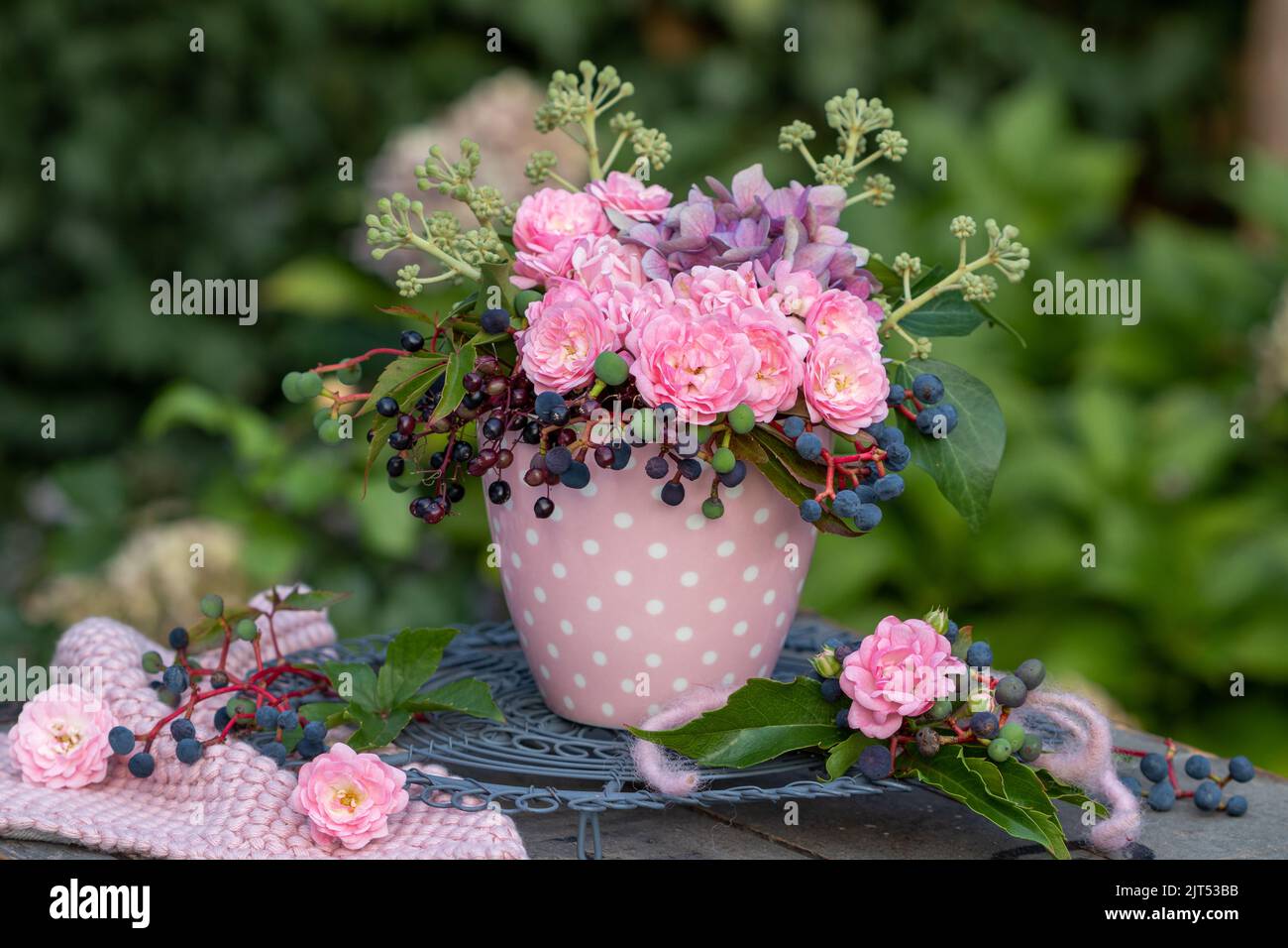 bouquet di rose rosa, fiori di ortensia, bacche di sambuco, bacche di vino selvatico e edera fruttata in tazza Foto Stock