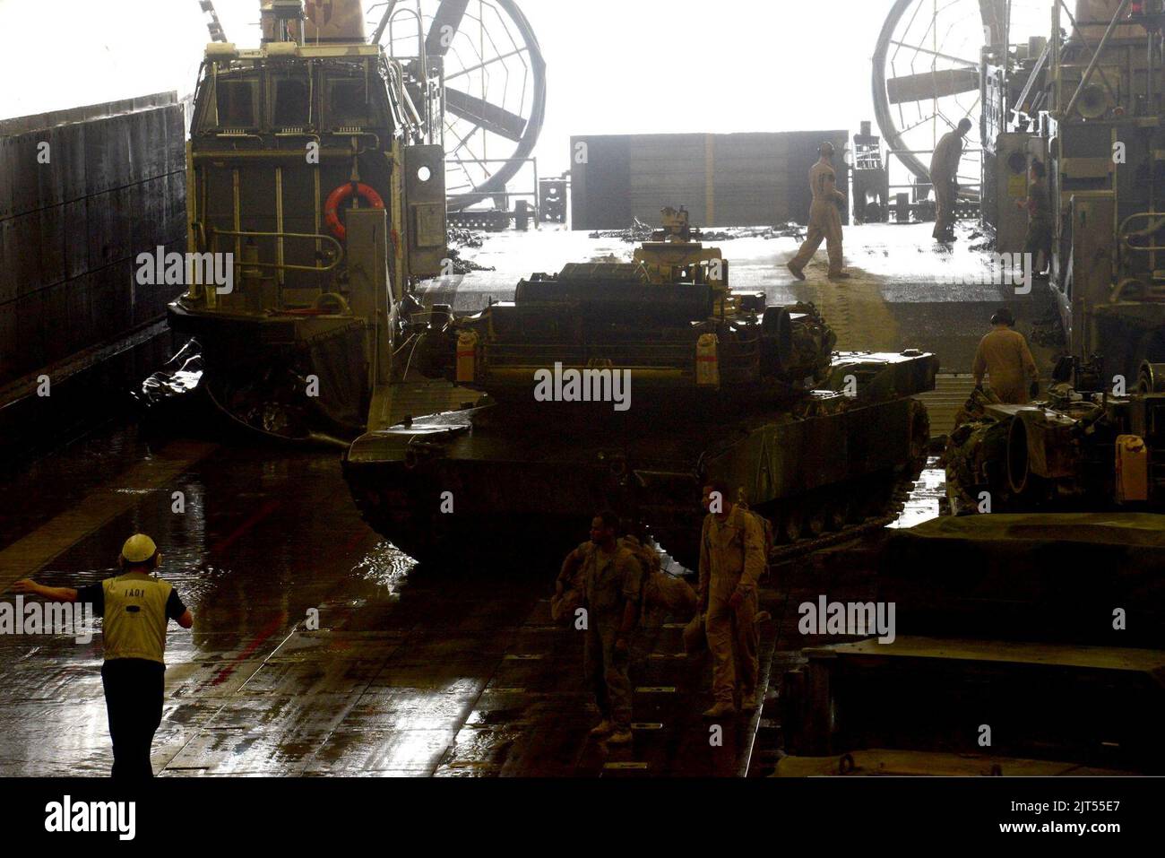 La U.S. Navy Boatswain's Mate 2nd Class dirige un carro armato M1A1 Abrams da un'imbarcazione da atterraggio, un cuscino d'aria nel ponte dei pozzi della nave d'assalto anfibia USS Bataan (LHD 5) nell'Arabian 140406 Foto Stock La U.S. Navy Boatswain's Mate 2nd Class dirige un carro armato M1A1 Abrams da un'imbarcazione da atterraggio, un cuscino d'aria nel ponte dei pozzi della nave d'assalto anfibia USS Bataan (LHD 5) nell'Arabian 140406 Foto Stock