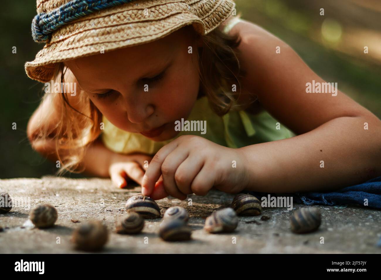Momenti di infanzia. Il bambino tiene le lumache nelle sue mani. Spazio di copia. Giochi all'aperto per bambini. Foto Stock