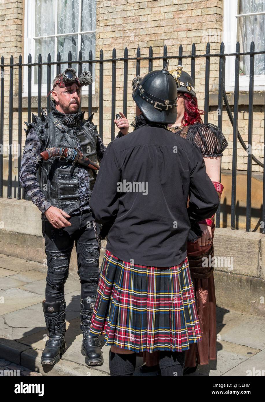 Tre persone vestite per il Lincoln Steampunk Festival parlare insieme, Castle Hill Lincoln 2022 Foto Stock