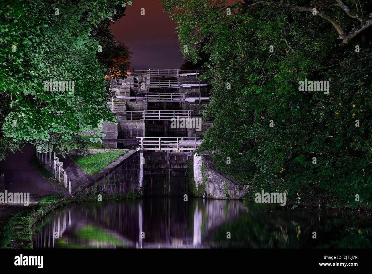 Cinque chiuse illuminate di notte sul canale da Leeds a Liverpool a Bingley, West Yorkshire. Foto Stock