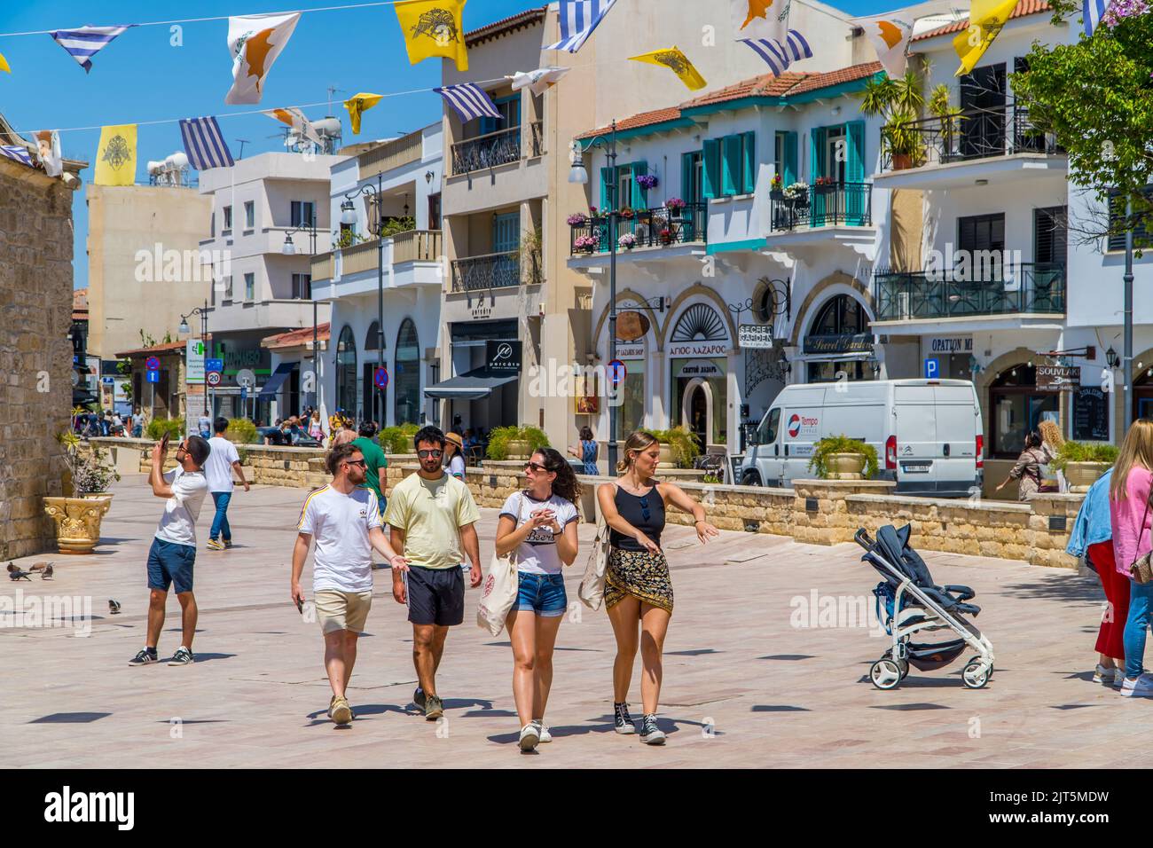Larnaca, Cipro - 22 aprile 2022 - fotografia candida dei giovani che camminano nel centro di Larnaca sotto il cielo blu Foto Stock