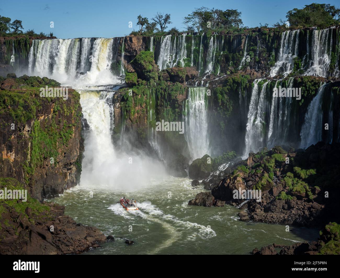 Barca turistica che esplora le cascate di Iguazu al confine tra Argentina e Brasile. Foto Stock