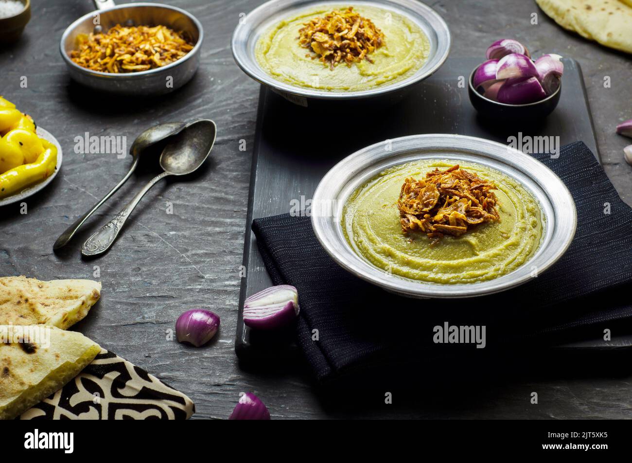 Cucina araba, fave egiziane e salsa alle erbe (Bessara). Contiene fave, cipolla, aglio ed erbe fresche. Foto Stock