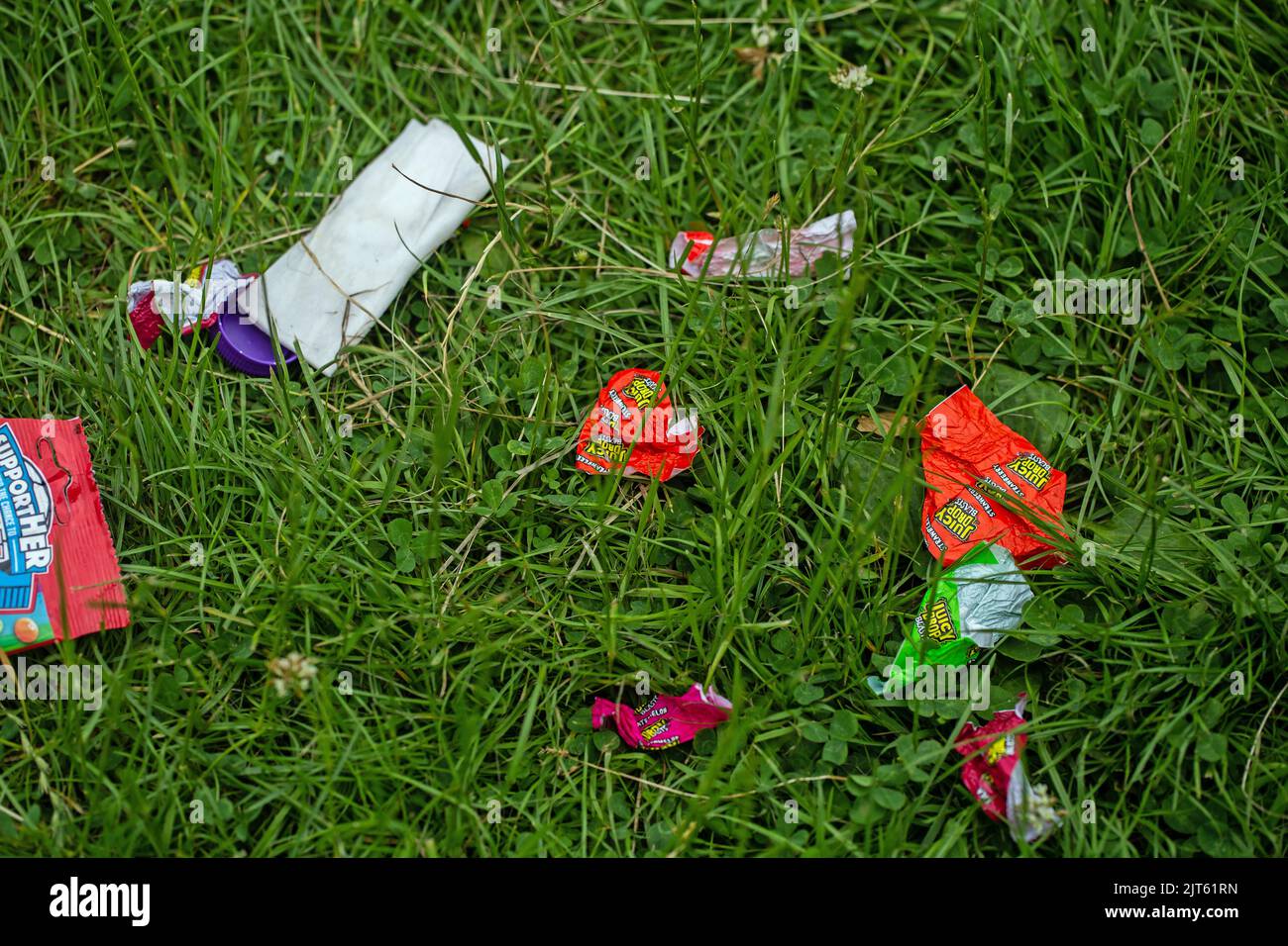 Wickford, Essex, Inghilterra, giugno 19th 2022, gli involucri dolci hanno lasciato in un pasticcio sull'erba Foto Stock