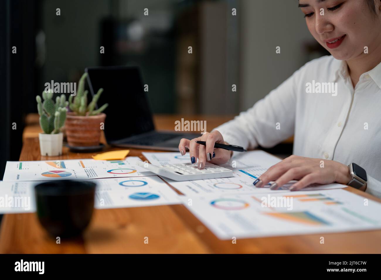 Donna d'affari che utilizza la calcolatrice per il concetto di tassazione, contabilità, statistica e ricerca analitica. Foto Stock