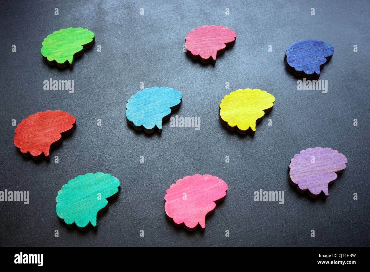 Concetto di Neurodiversità. Figure multicolore del cervello su una superficie scura. Foto Stock