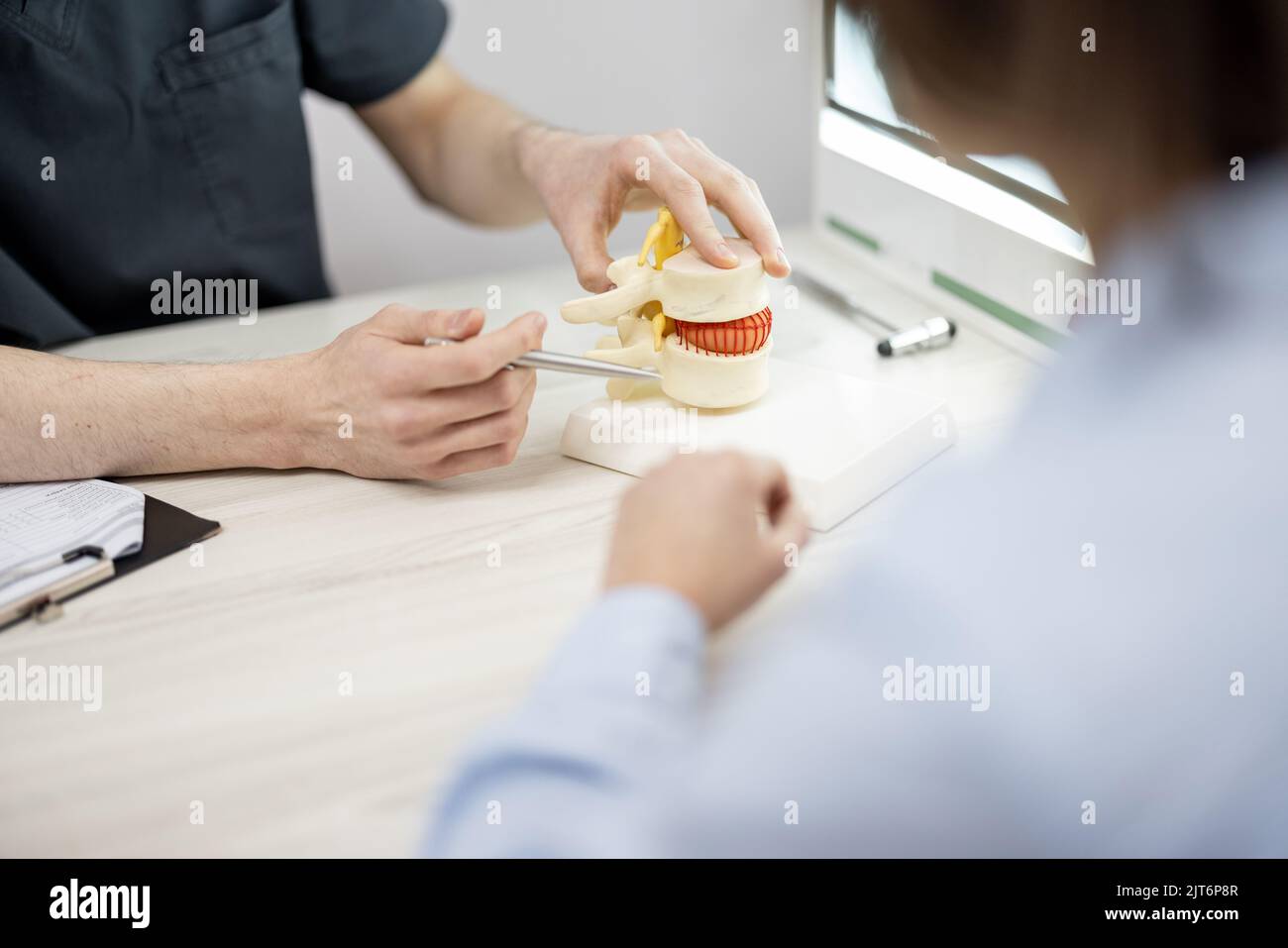 Giovane donna in consultazione con un fisioterapista presso l'ufficio medico Foto Stock