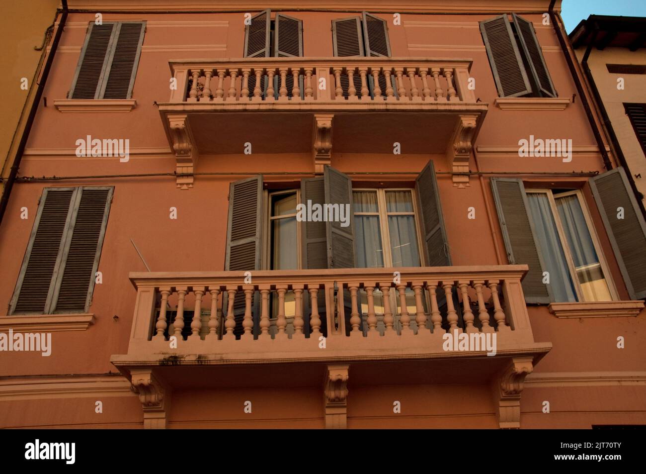 Casa con veranda e persiane, Parma, Emiglia Romagna, Italia. Casa dipinta in colori luminosi con persiane e balconi. Foto Stock