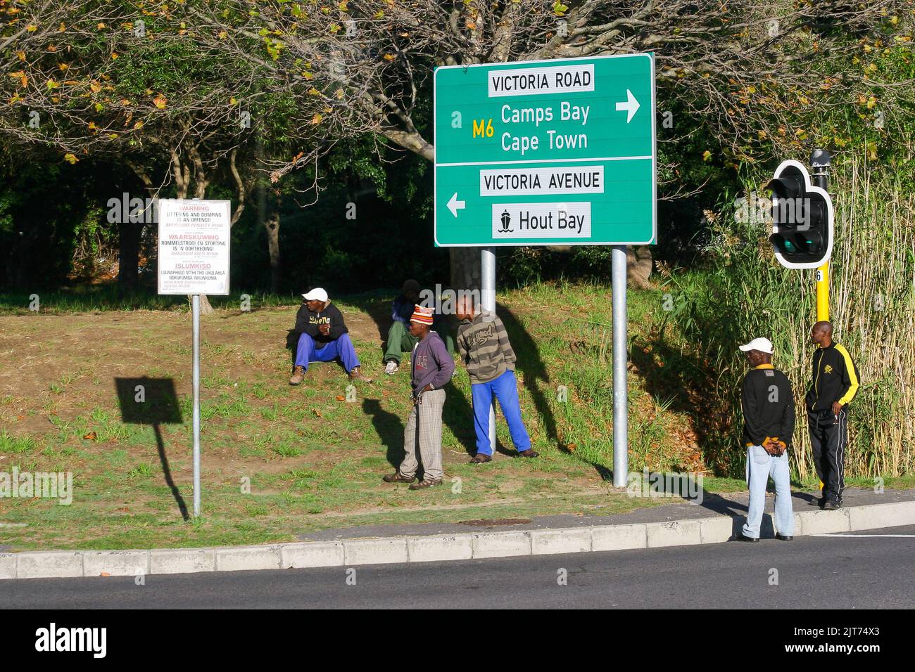 Città del Capo, Sud Africa - 04 16 2012: Giovani lavoratori in attesa di lavoro a fianco di Hout Bay Road in Sud Africa Foto Stock