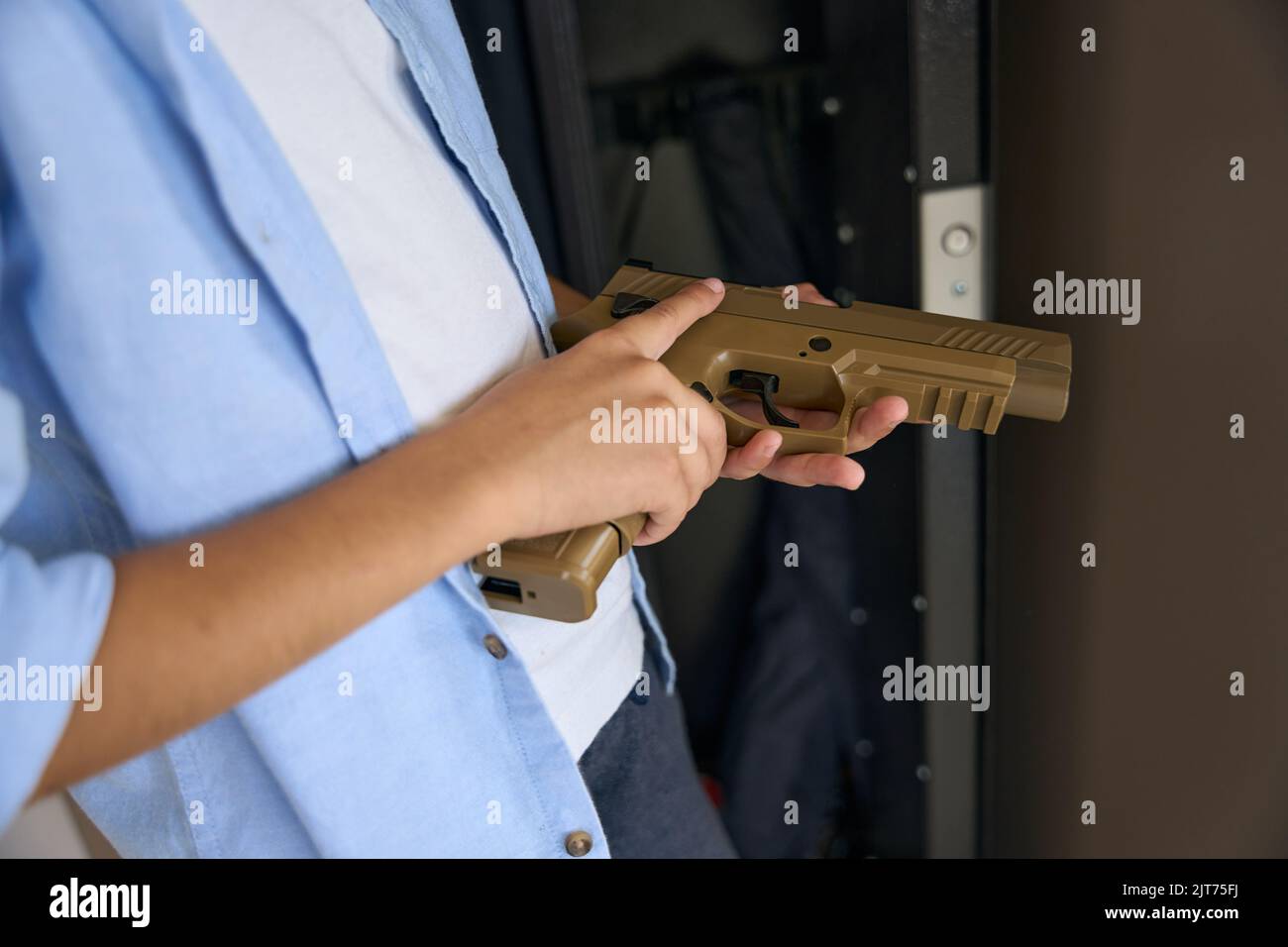 Pistola di plastica nelle mani di un ragazzo adolescente Foto Stock