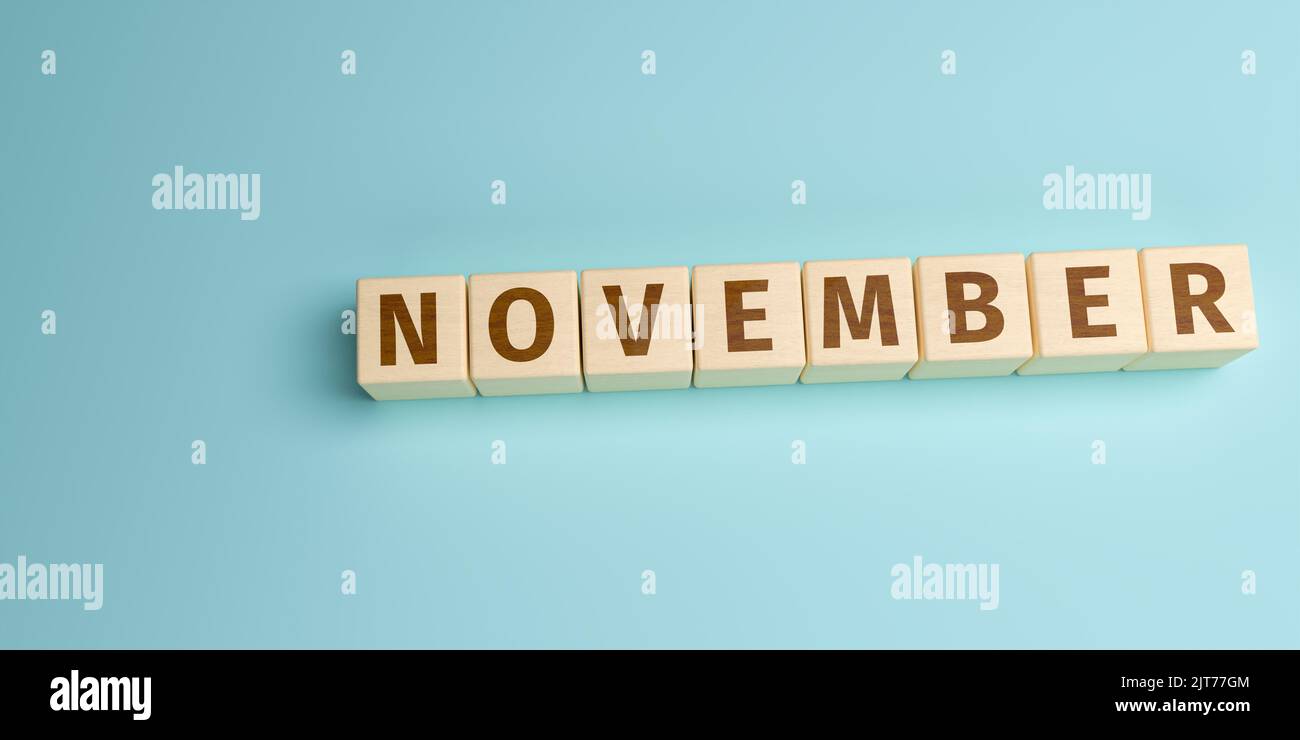 La parola novembre costruita da lettere su cubi di legno. Vista ad angolo alto con spazio di copia Foto Stock