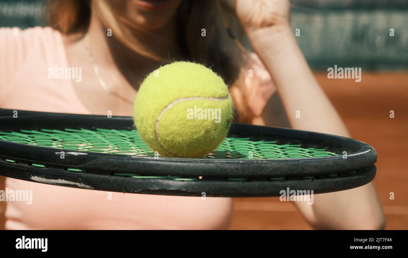 Ragazza che tiene un racchetta da tennis con una palla da tennis Foto Stock