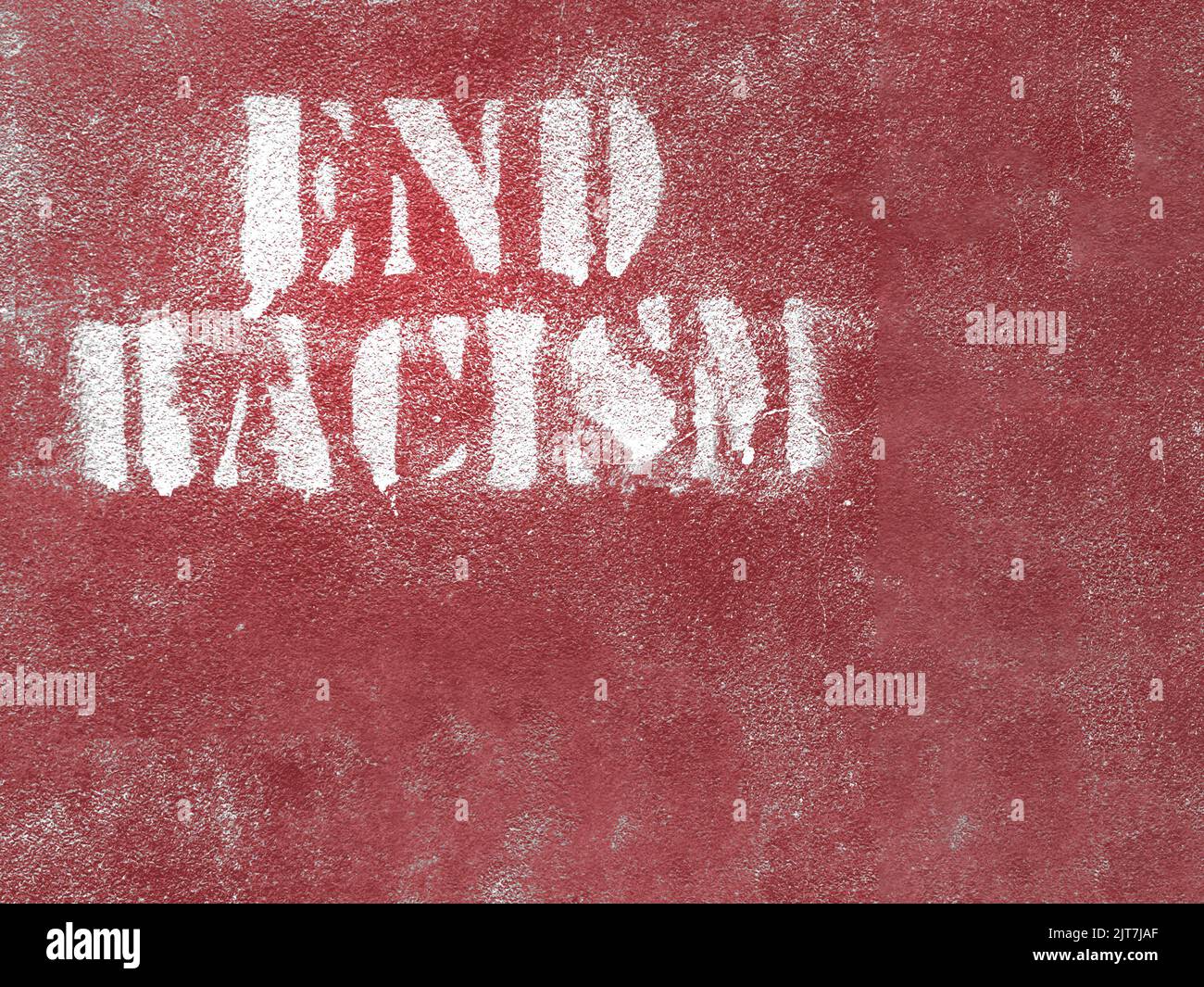 Fine del messaggio sul razzismo sul muro. PORRE FINE AL RAZZISMO sul muro rosso. Ideale per concetti e sfondi. Spazio per il testo. Foto Stock