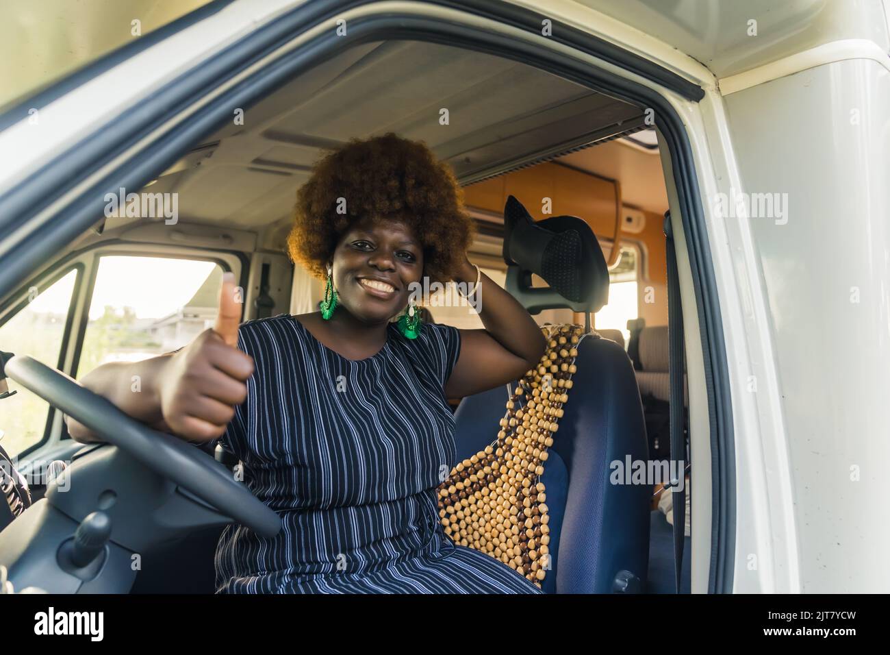 Felice Afro-americana donna seduta al volante e mostrando OK segno. Foto di alta qualità Foto Stock