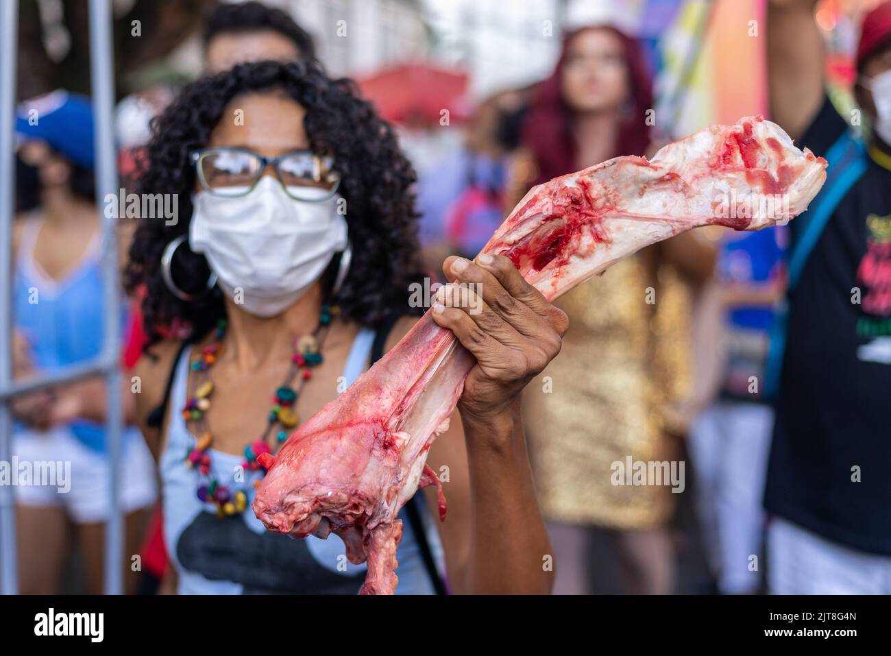 Salvador, Bahia, Brasile - 09 aprile 2022: Una donna che protesta contro la candidata presidenziale di estrema destra Jair Bolsonaro, con osso bovino nelle sue mani sy Foto Stock