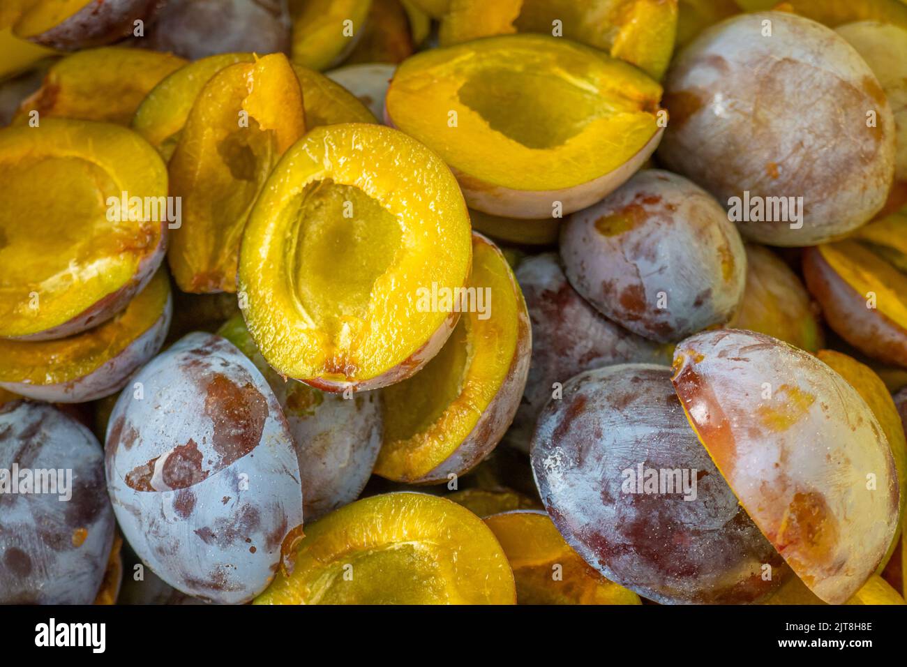 Prugne metà sfondo. Polpa succosa di consistenza di prugne. Frutte biologiche.prugne Harvest.prugne marmellata preparation.plum abbondanza Foto Stock