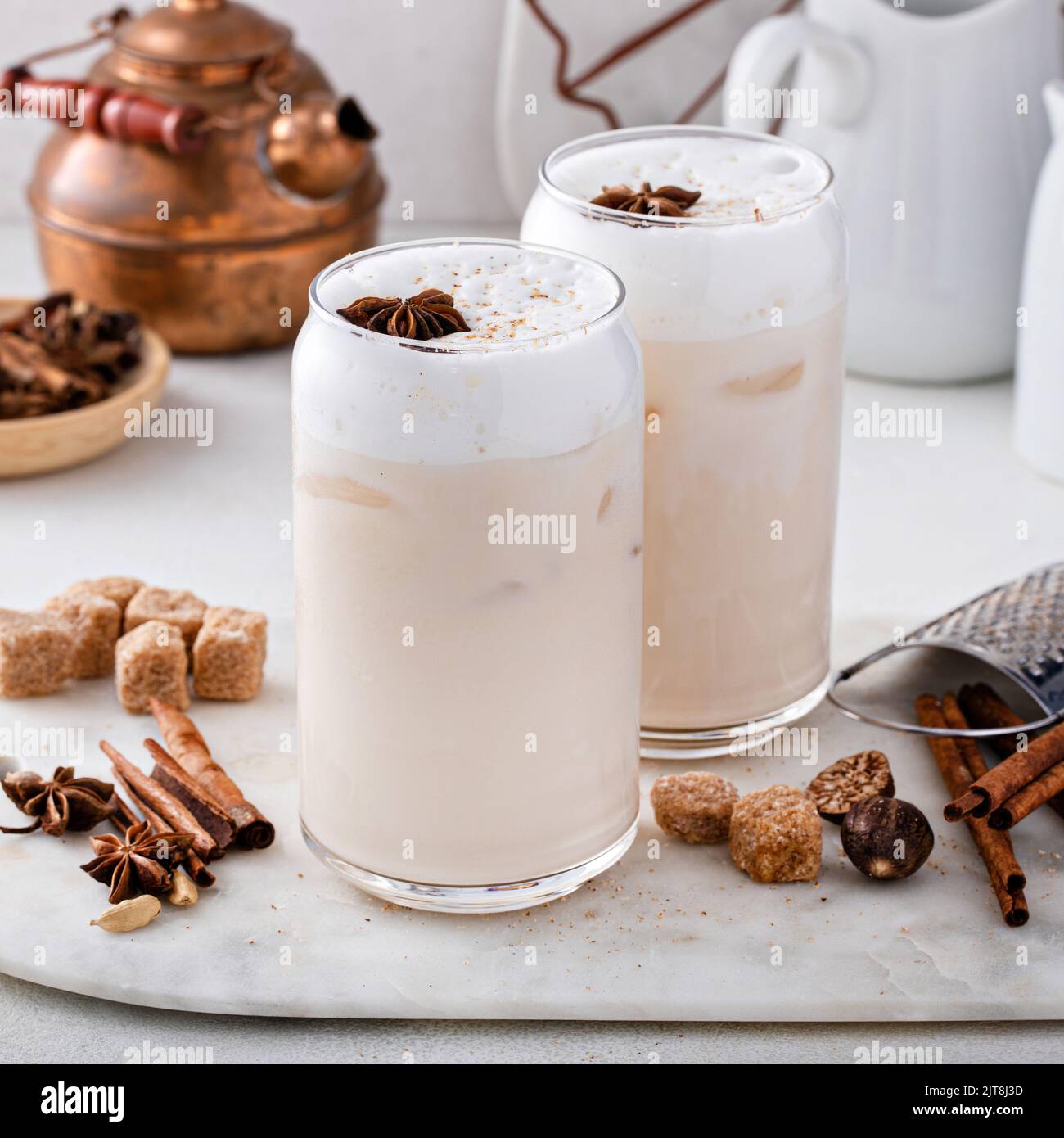 Latte di chai ghiacciato con spezie invernali calde sormontato da schiuma di latte Foto Stock