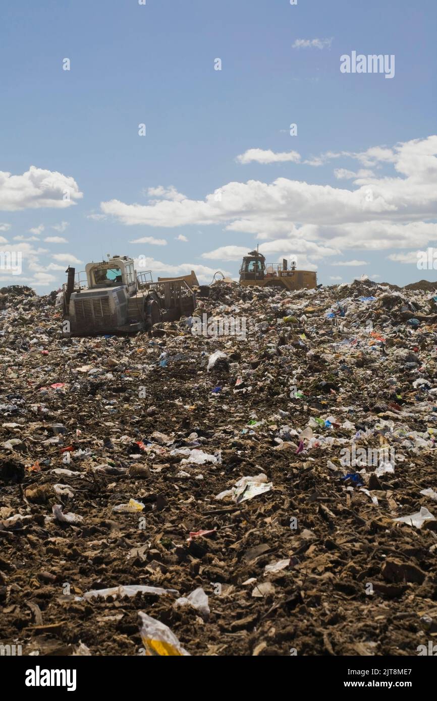 I bulldozer si diffondono e compattano i detriti e i rifiuti scartati nel sito di gestione dei rifiuti, Quebec, Canada Foto Stock