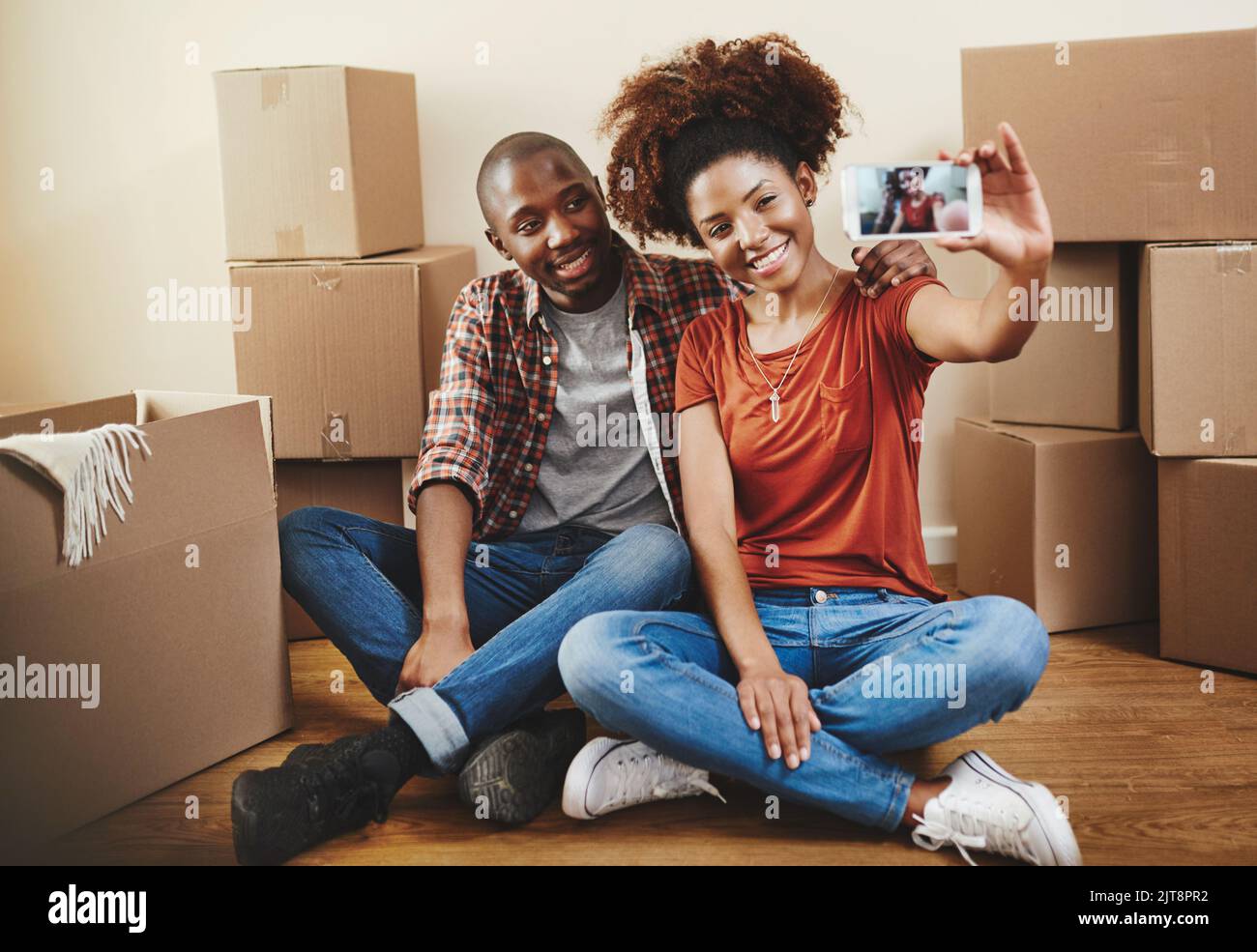 Muoversi insieme è una parte importante di qualsiasi rapporto: Una giovane coppia che prende un selfie nella loro nuova casa. Foto Stock