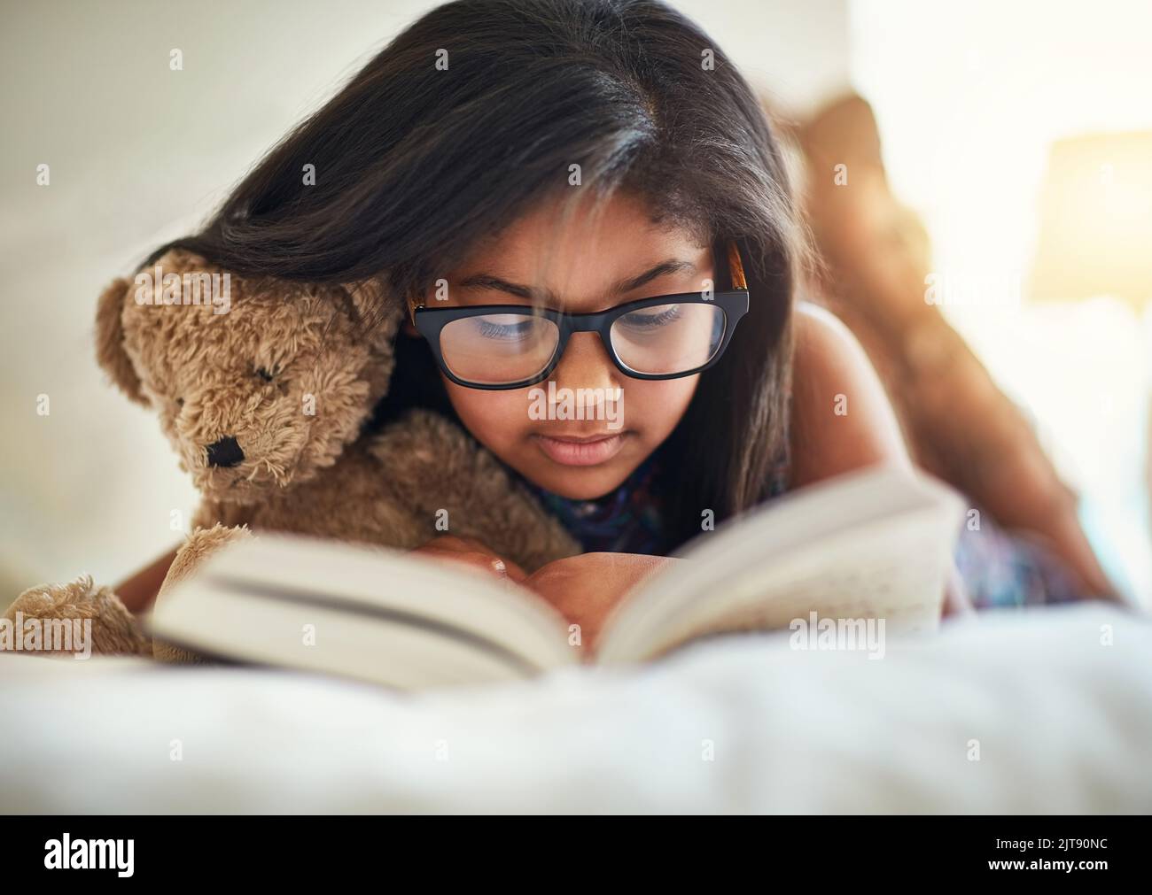 Un amante dei libri. Una ragazza carina che legge un libro nella sua camera da letto. Foto Stock