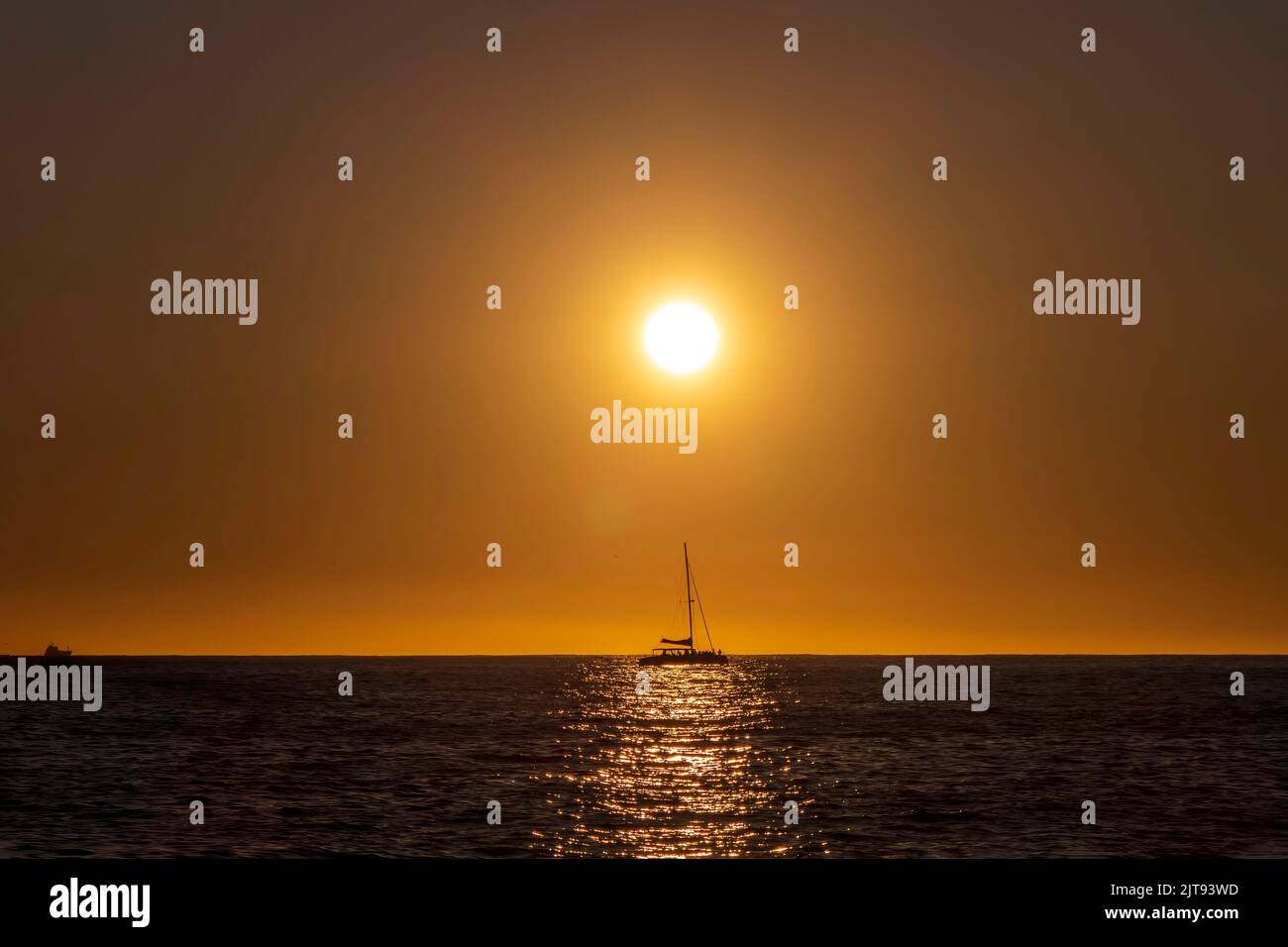 Barche di mare sullo sfondo del sole riflesso nelle onde. Un incredibile tramonto sull'Oceano Atlantico. Foto Stock