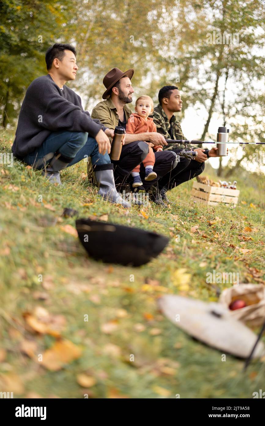 Gli amici maschi multirazziali riposano in natura in autunno Foto Stock