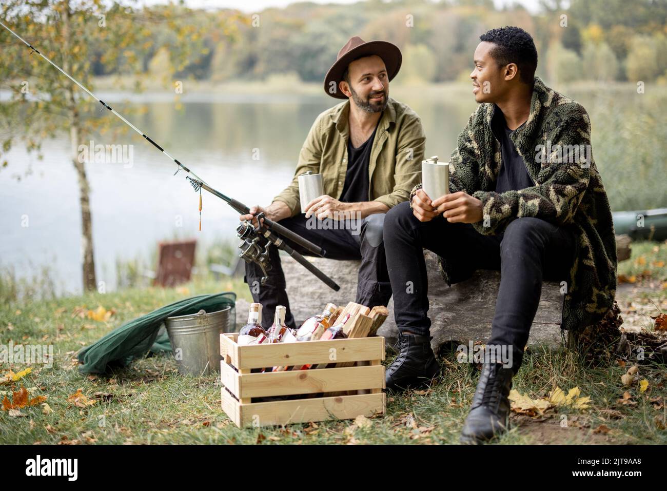 Uomini con alcol sulla pesca all'aperto Foto Stock