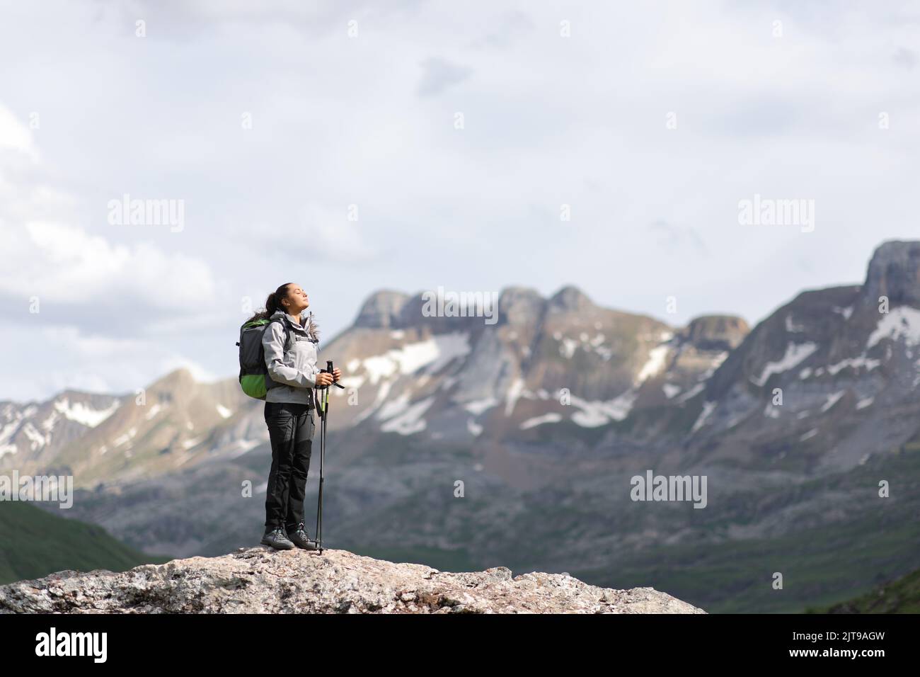 Ritratto integrale di un escursionista che respira aria fresca in un'alta cima di montagna Foto Stock