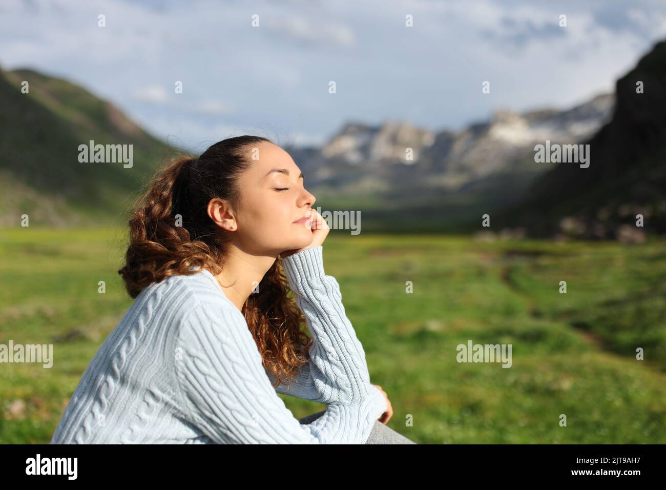 Donna mente rilassante una giornata di sole in montagna Foto Stock