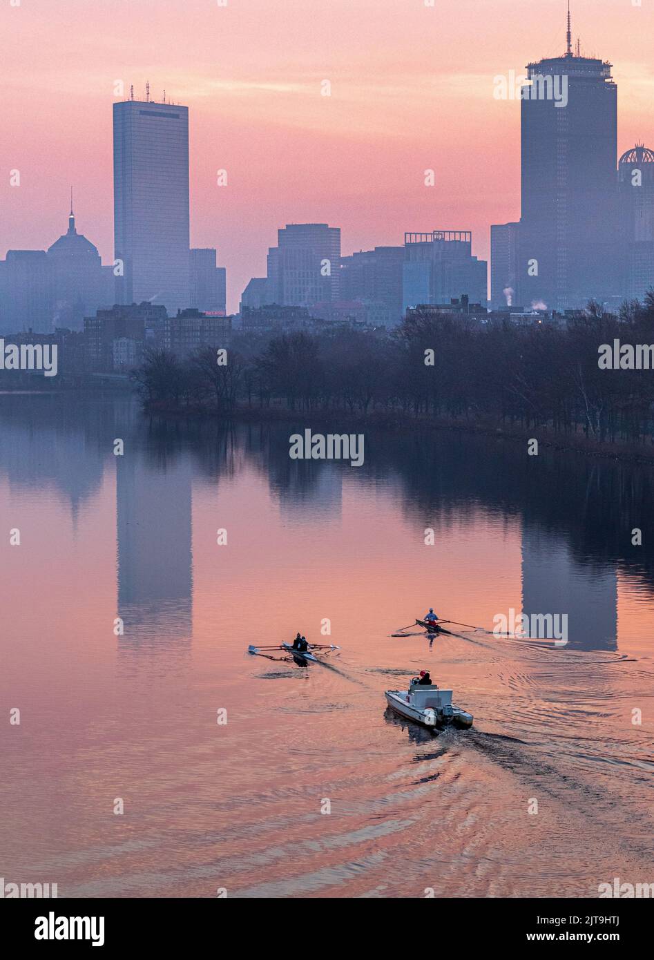 Uno scatto verticale dei vogatori lungo il fiume Charles all'alba con lo skyline di Boston, USA Foto Stock
