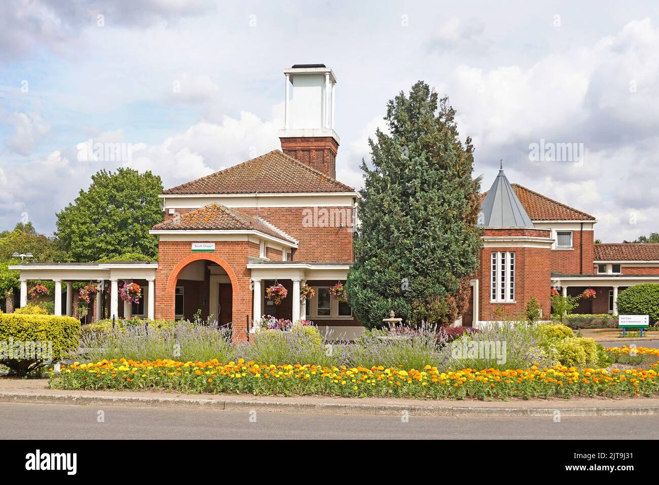 Fiori e giardini estivi ben curati intorno agli edifici in mattoni della South & East Chapel a South Essex crematorium Corbets Tey Upminster Londra Inghilterra Regno Unito Foto Stock