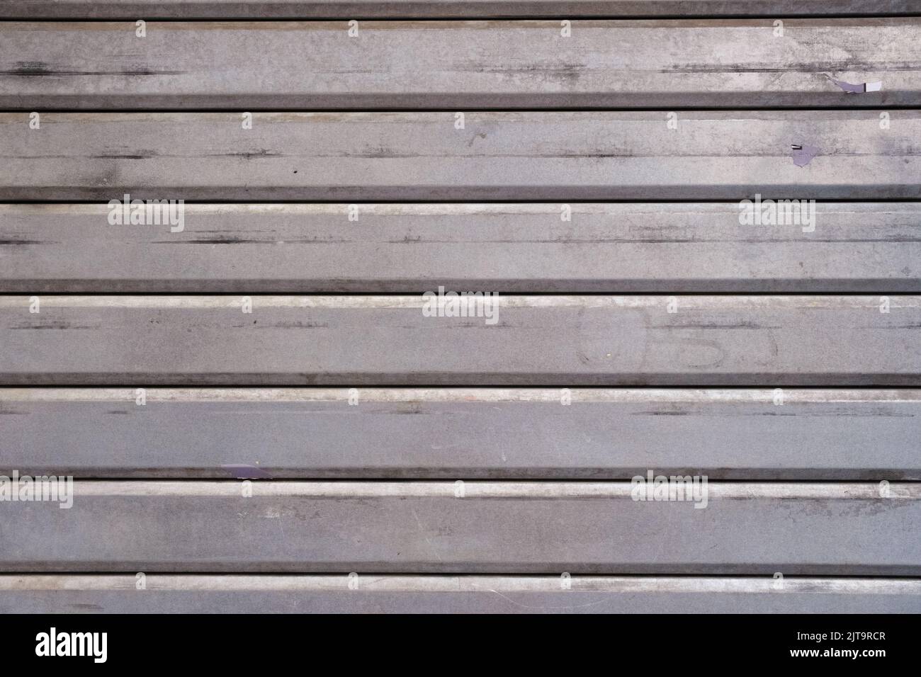Parete sporca d'acciaio del garage, primo piano, grunge texture e modello, vintage grigio porta orizzontale a strisce, sfondo. Foto Stock