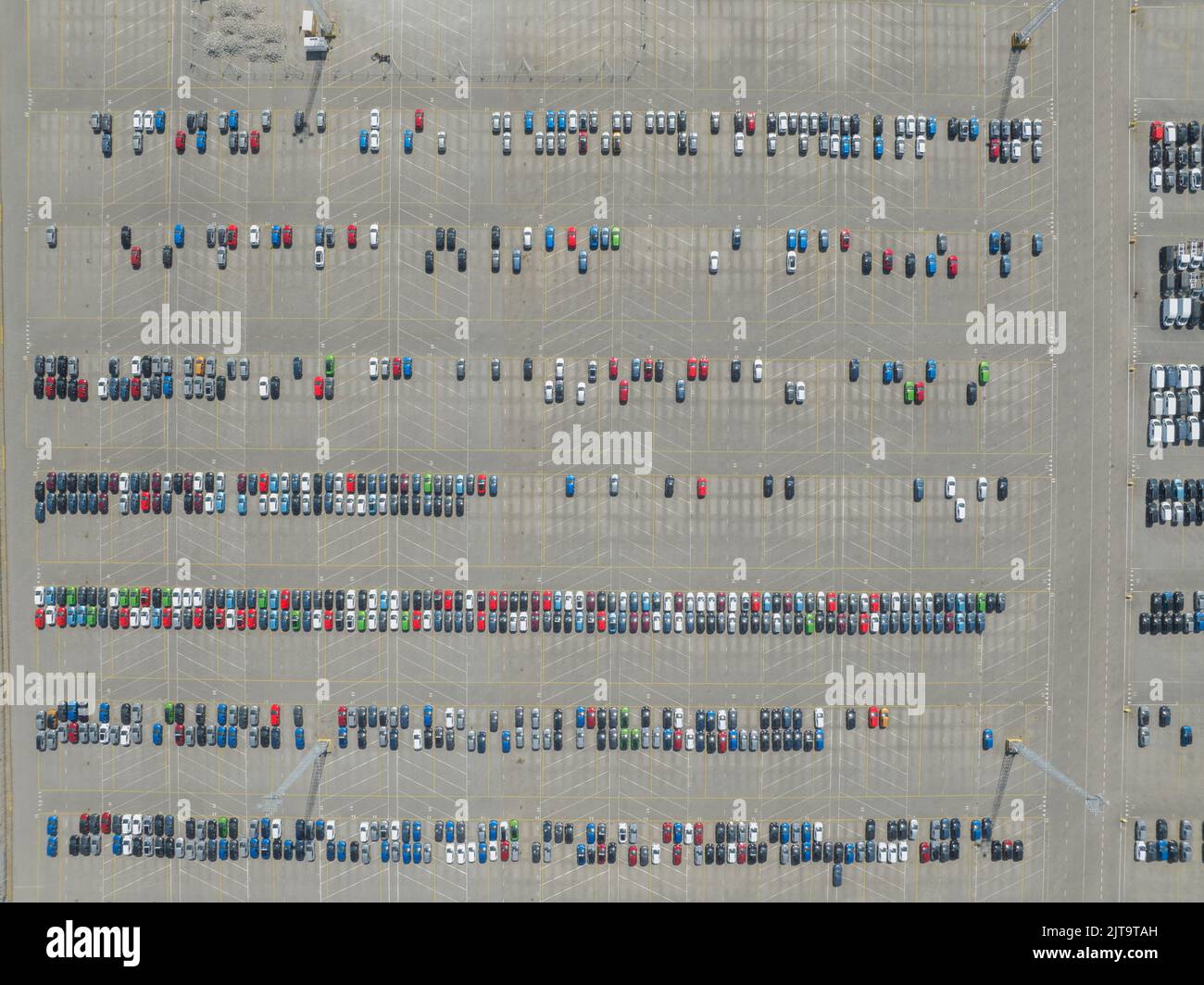 Vista dall'alto verso il basso del deposito di automobili di importazione ed esportazione nel porto. Industria automobilistica nuovi veicoli parcheggiati lotto pronto per la spedizione Foto Stock