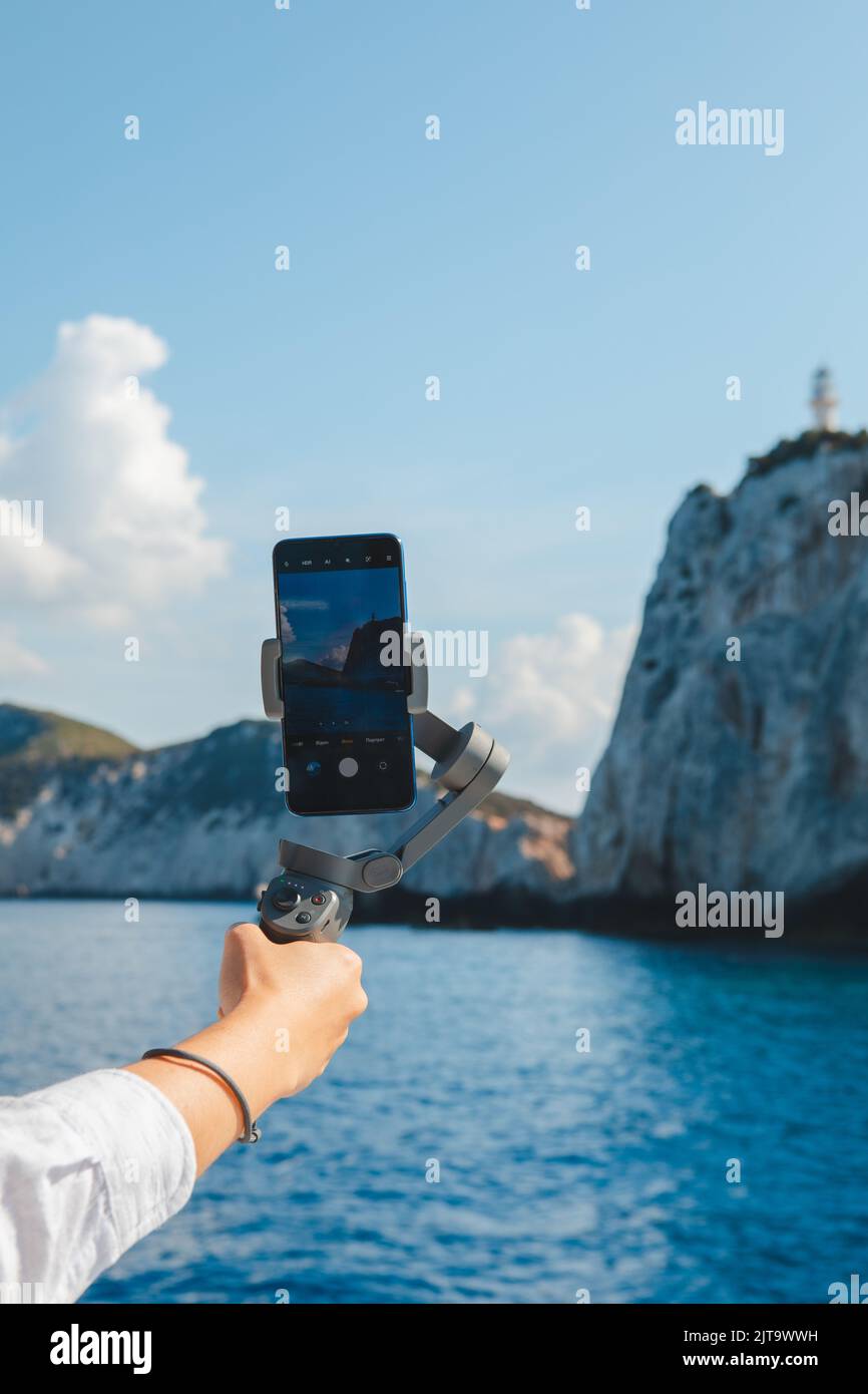 telefono con stabilizzatore a mano che scatta una vista panoramica dell'isola di lefkada Foto Stock