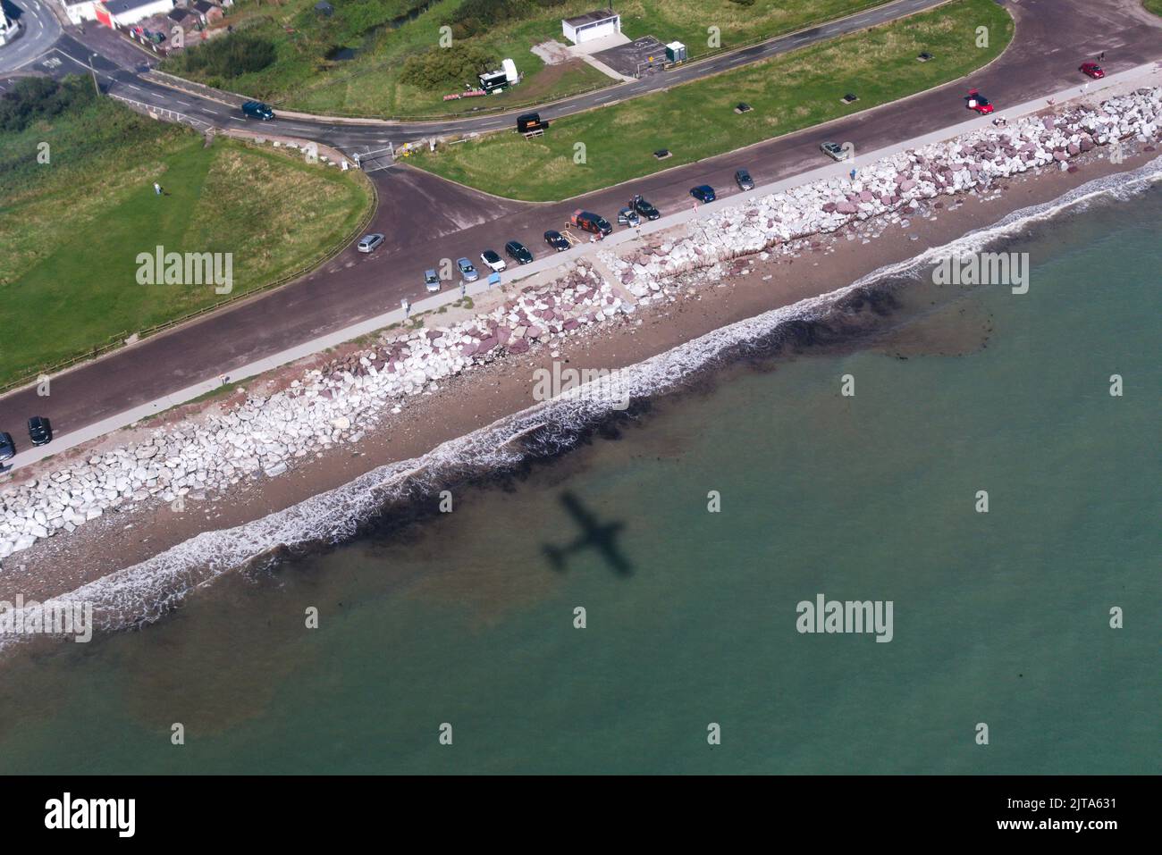Un aereo ombra vola lungo una spiaggia irlandese Foto Stock