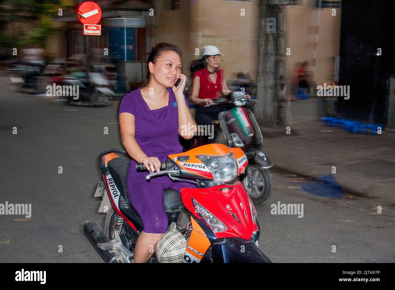 Vietnam, Hanoi utilizzando il telefono cellulare durante la guida è un'abitudine comune da parte della maggior parte delle persone. Foto Stock