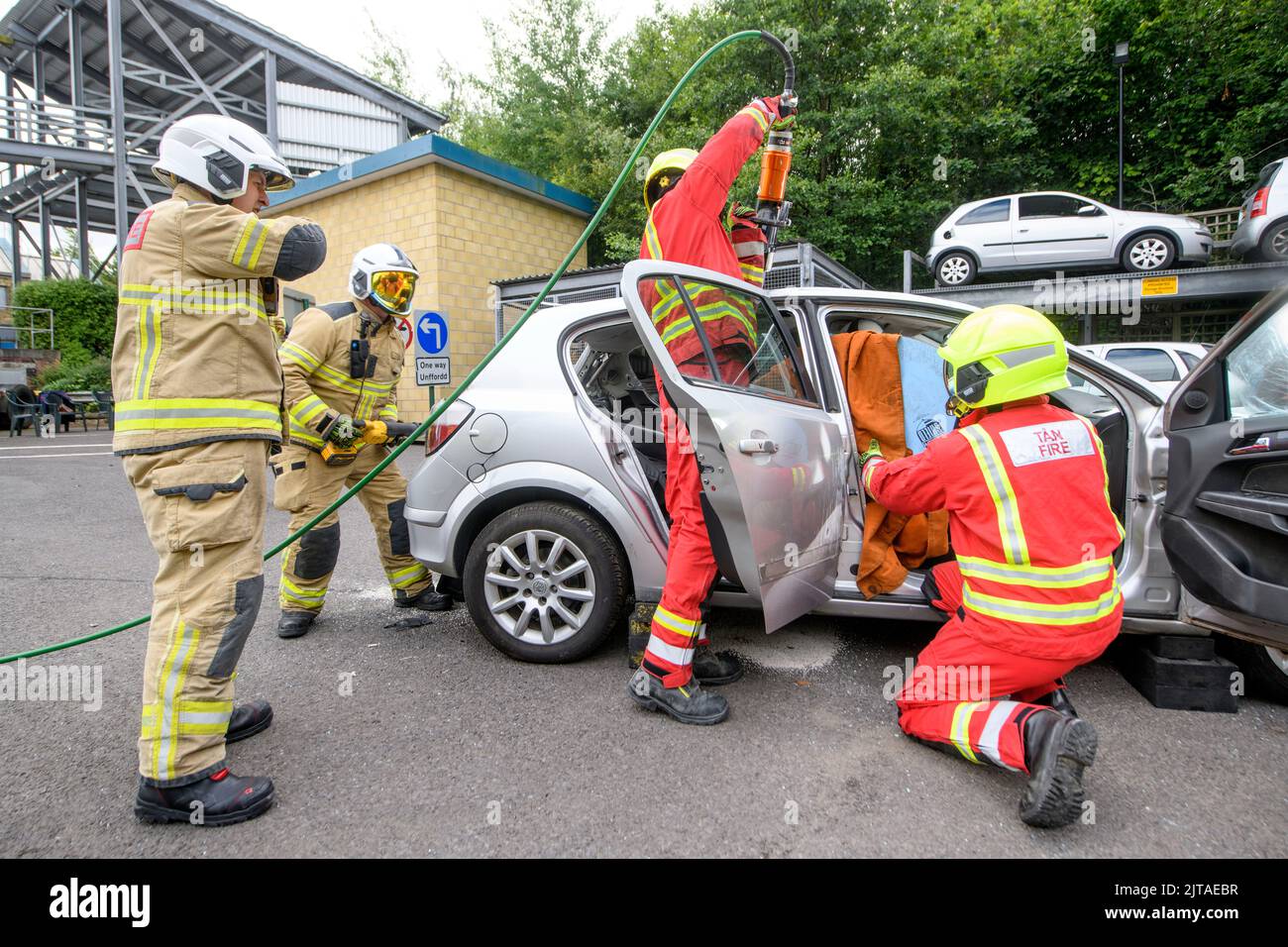 I vigili del fuoco utilizzano attrezzature specializzate per esercitarsi a estrarre uno stand nel conducente che indossa i sensori al Cardiff Gate Training Centre. Foto Stock
