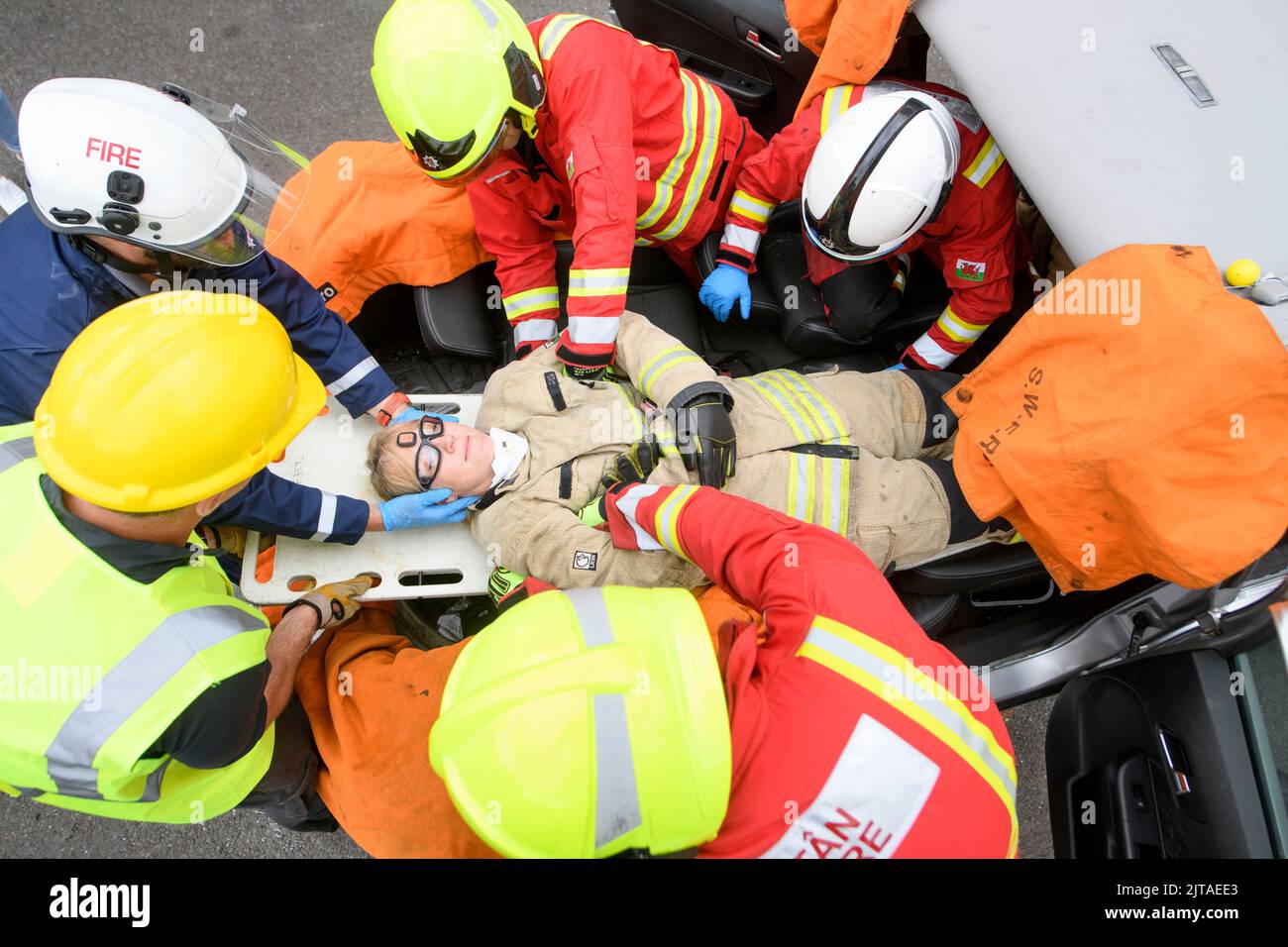 I vigili del fuoco utilizzano attrezzature specializzate per esercitarsi a estrarre uno stand nel conducente che indossa i sensori al Cardiff Gate Training Centre. Foto Stock