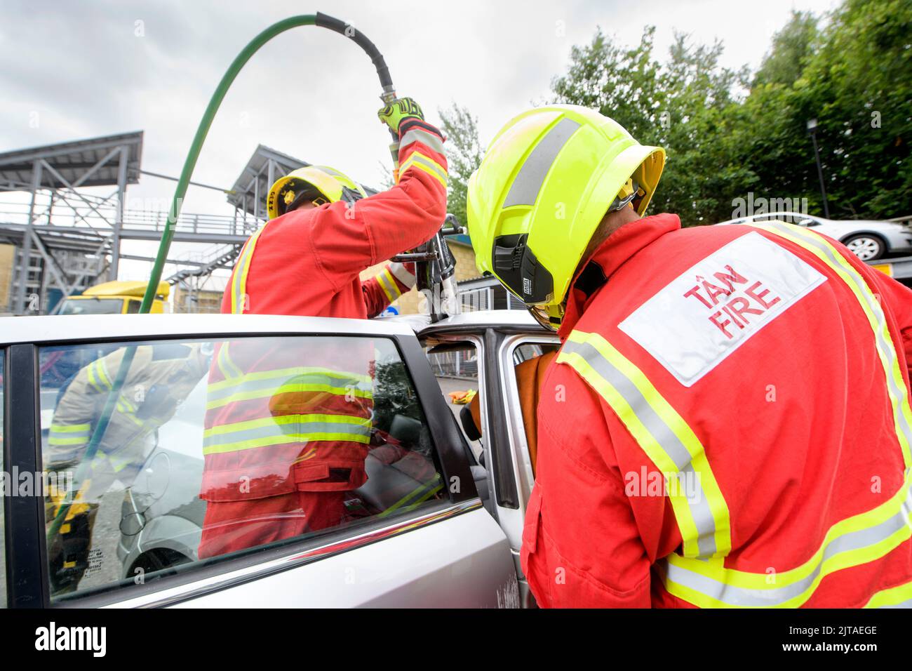 I vigili del fuoco utilizzano attrezzature specializzate per esercitarsi a estrarre uno stand nel conducente che indossa i sensori al Cardiff Gate Training Centre. Foto Stock