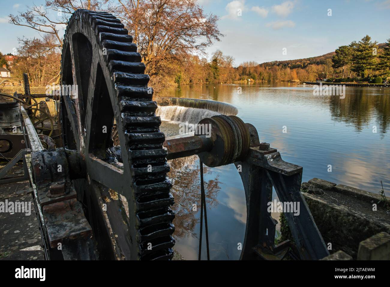 Ruota motrice chiusa e stramazzo sul fiume Derwent, parte del sistema idrico che un tempo guidava i mulini di cotone a Belper, Derbyshire, Regno Unito Foto Stock
