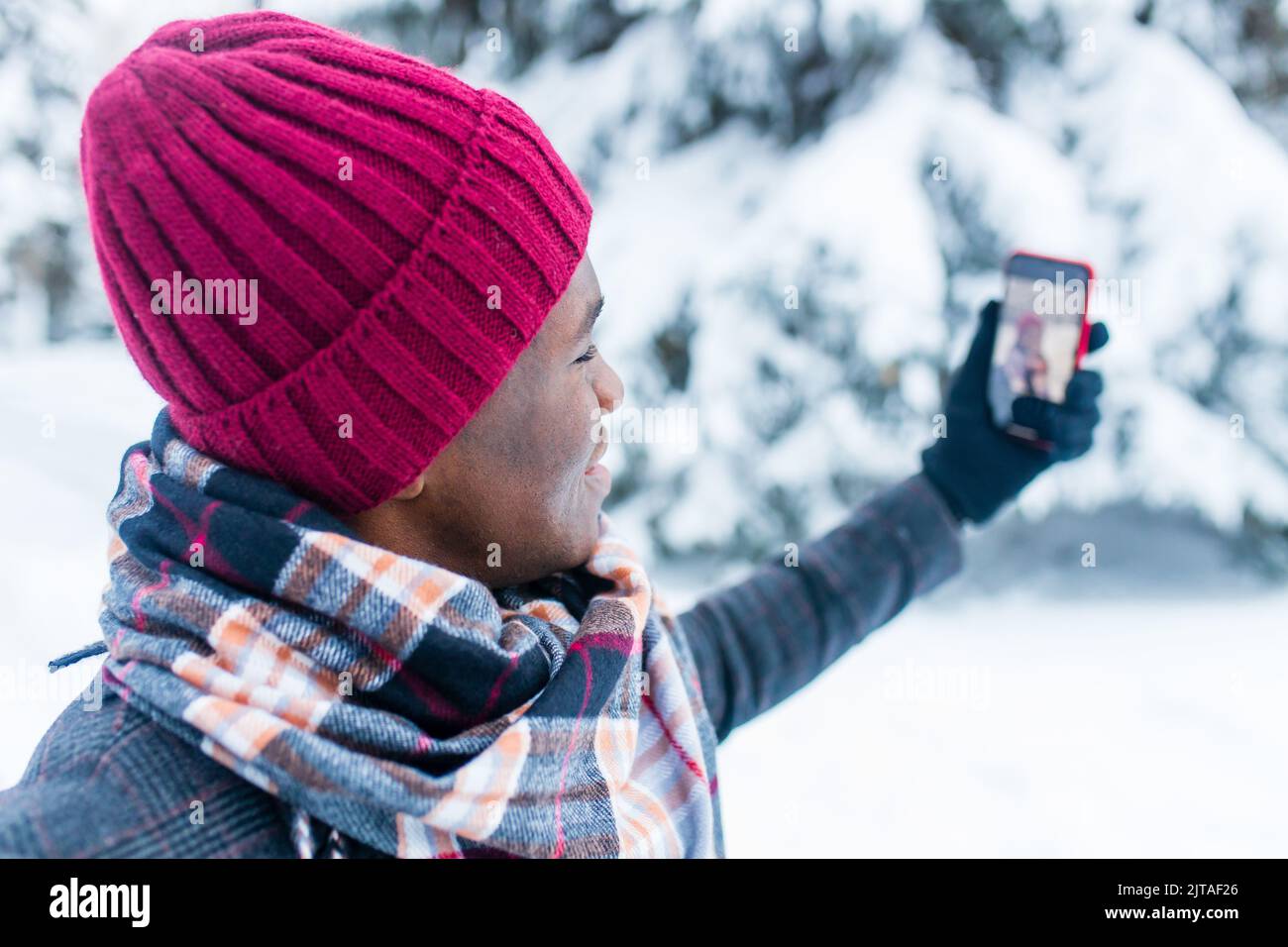 uomo ispanico parlando in video connettersi da smartphone con amici di famiglia e congratulazioni buon natale Foto Stock