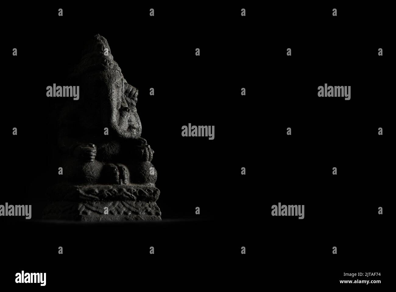 Statua in miniatura di Ganesha con illuminazione laterale a basso tasto Foto Stock
