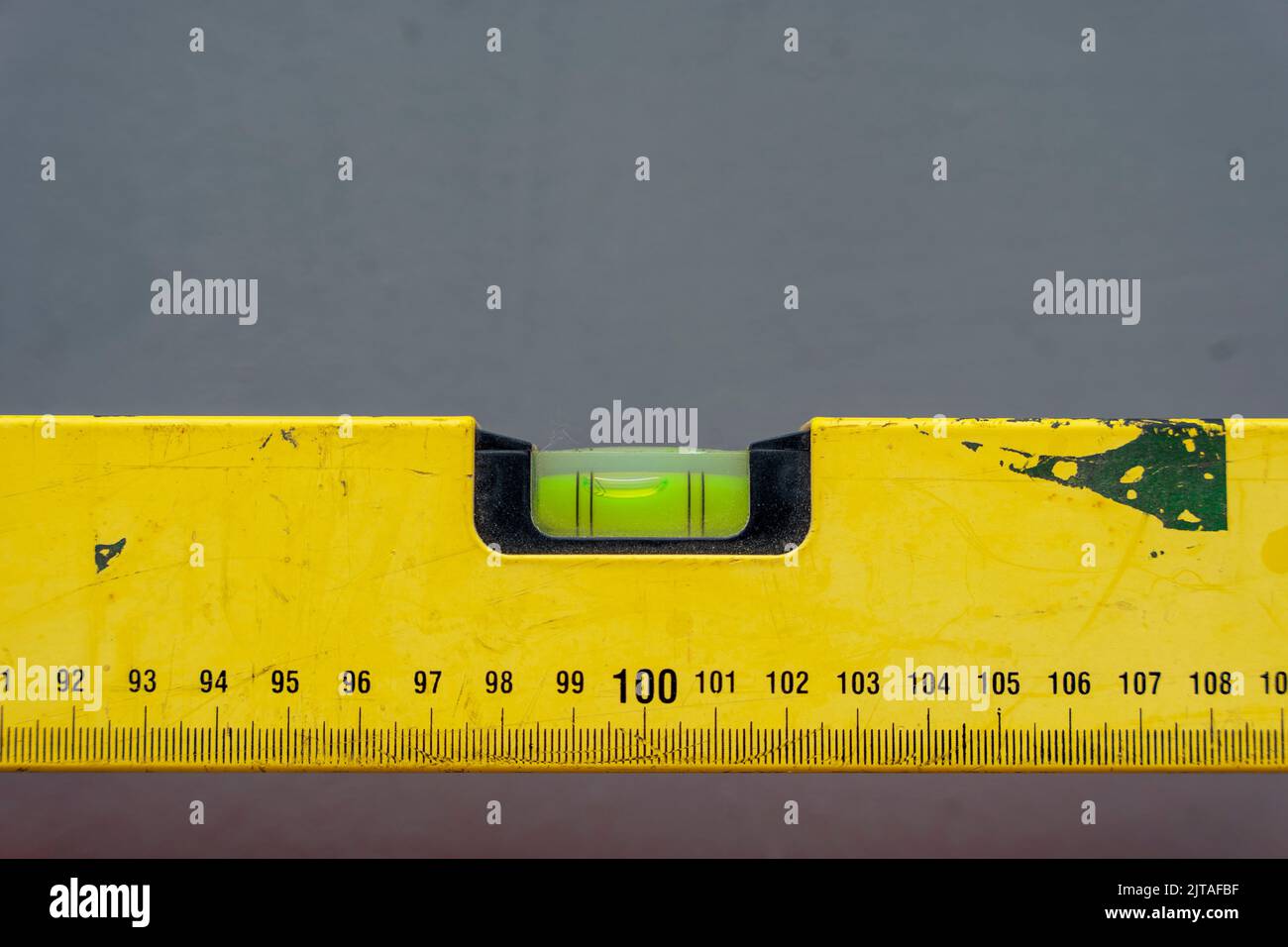 livella a bolla con una marcatura di lunghezza su sfondo grigio Foto Stock