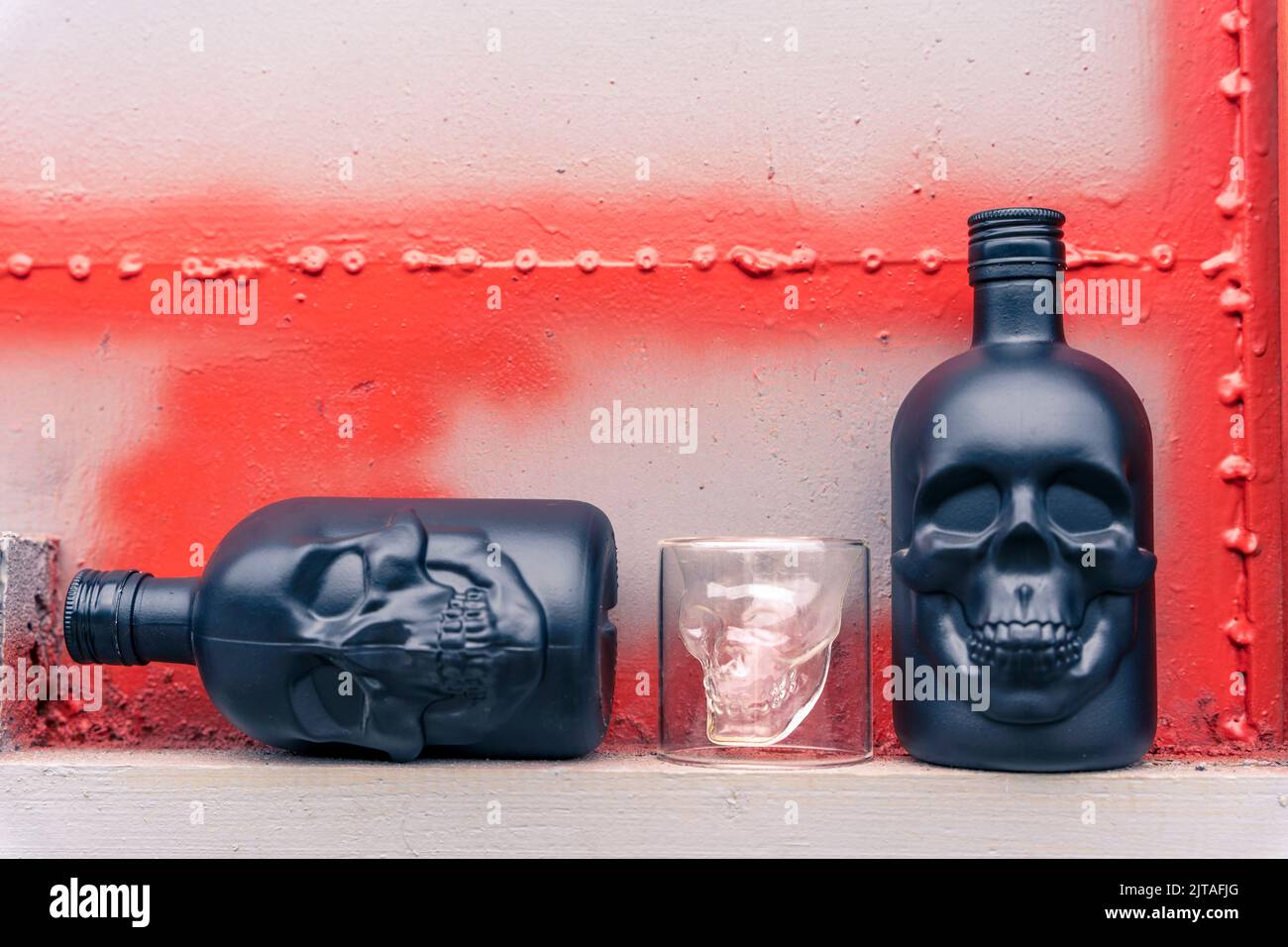 bottiglie in gin di vetro a forma di cranio umano e di pila di vetro Foto Stock