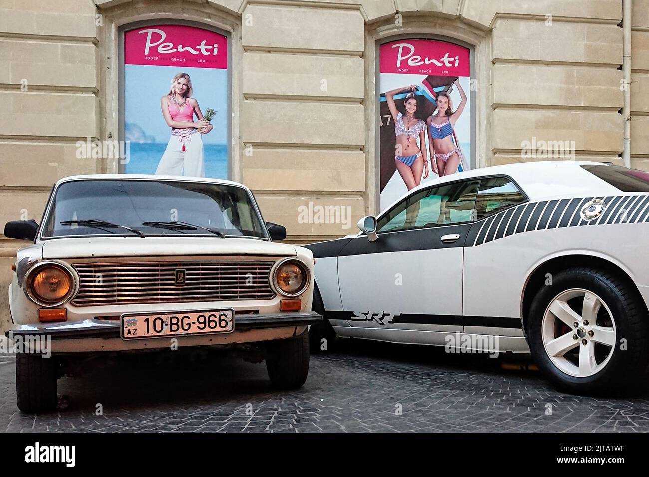 Una Lada di produzione russa parcheggiata accanto ad una macchina muscolare americana a Baku, Azerbaigian Foto Stock