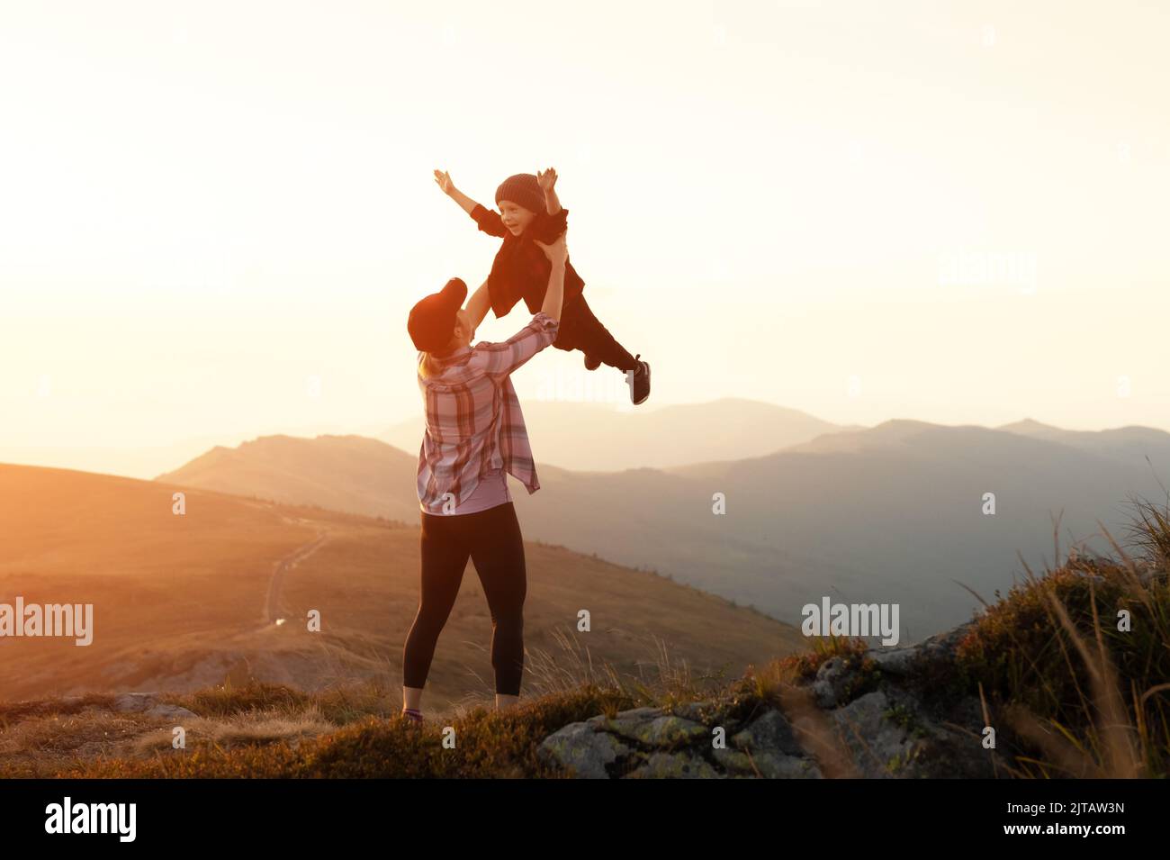 Mamma con figlio nelle montagne autunnali durante il tramonto. Viaggia con bambino concetto Foto Stock